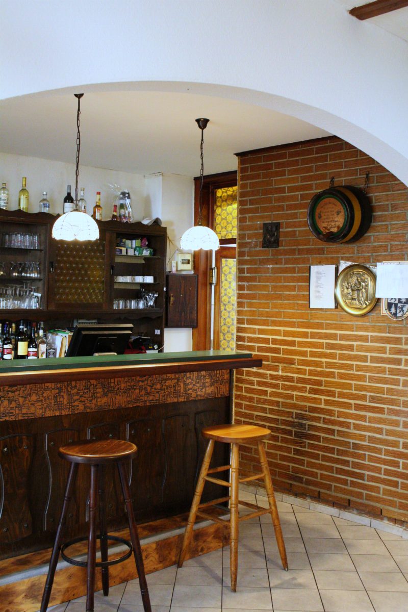 Theke mit Barhockern unter dem Rundbogen